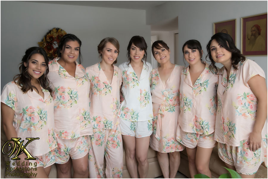 bride and her bridesmaids in light pink floral robes.