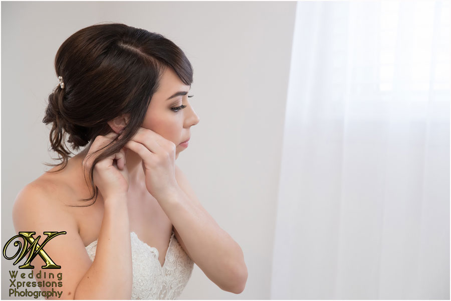 bride putting on her earings captured by Wedding Xpressions Photography in El Paso
