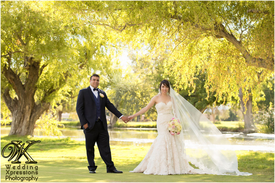 Felix & Emily posing in from of lake at Dos Lagos Golf Course by Wedding Xpressions Photography