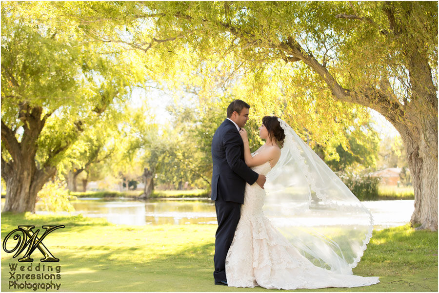 Wedding Xpressions Photography captured couple in frot of lake and trees looking into each others eyes.