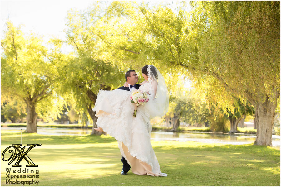 groom carrying bride near lake in El Paso Texas