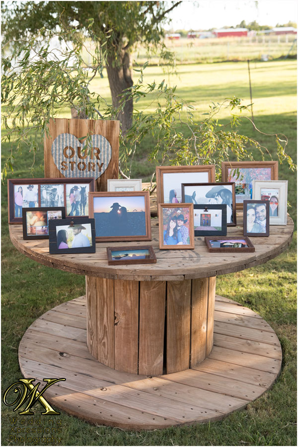 Our Story wedding table showing many framed photos of couple Felix & Emily