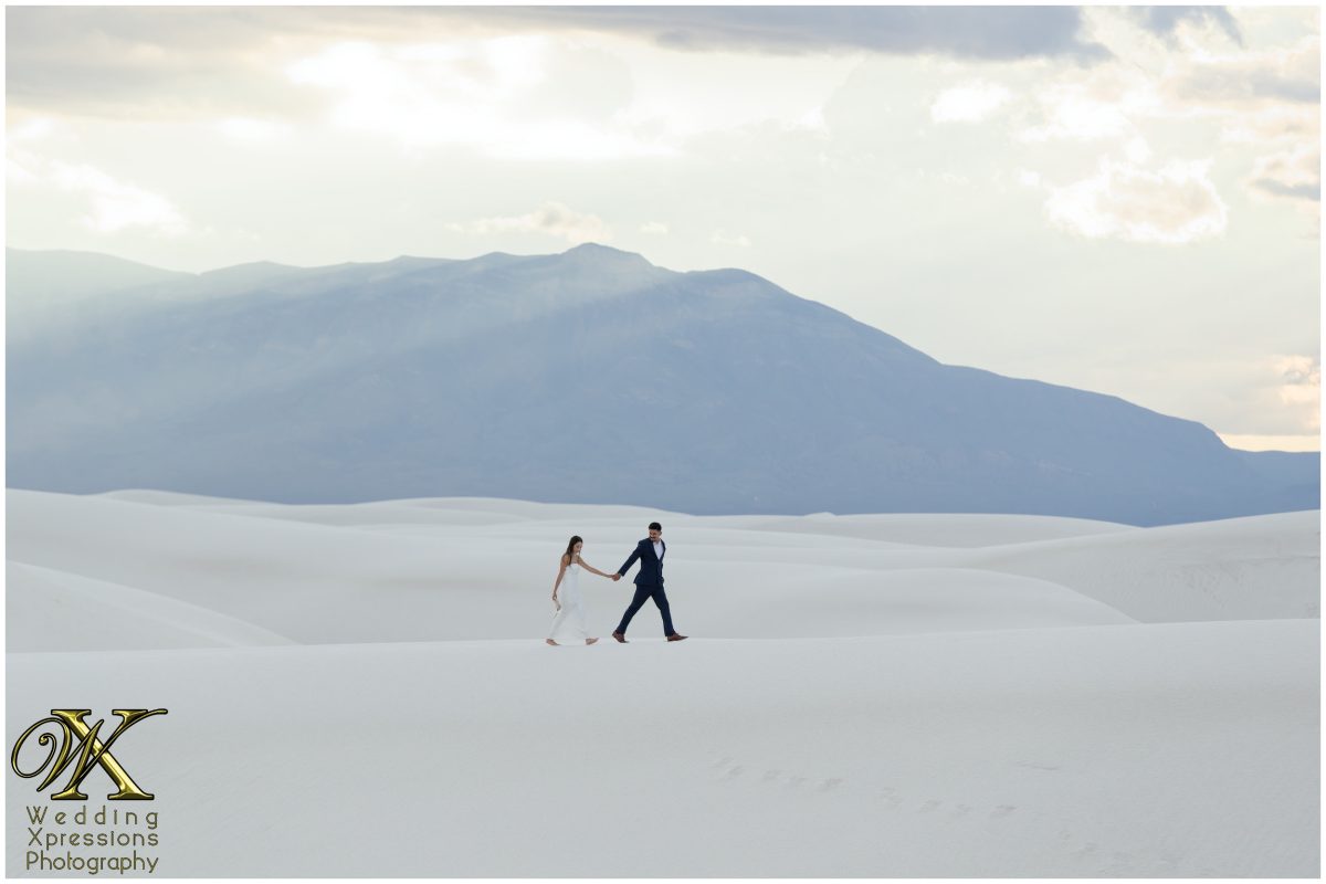 Couple silhouetted against a moody sky at White Sands.