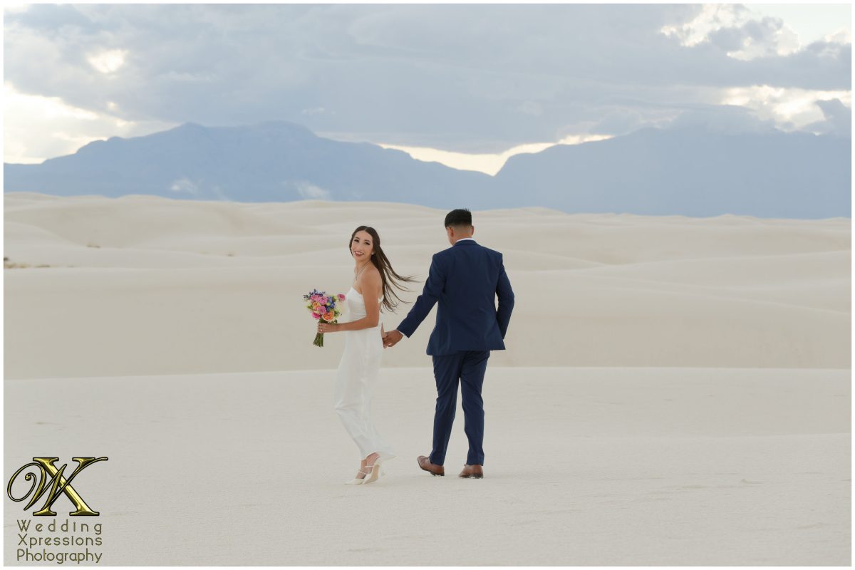 Couple walking through the desert brush near White Sands.