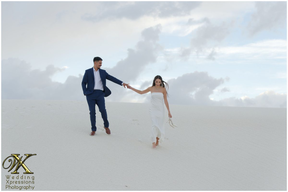 Alan and Illiana standing together against a cloudy desert sky.