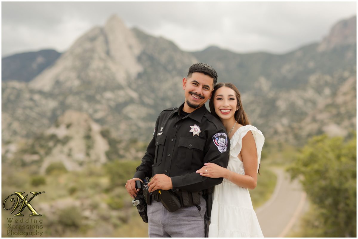 Portrait of couple in police uniform and nurse scrubs in the mountains.