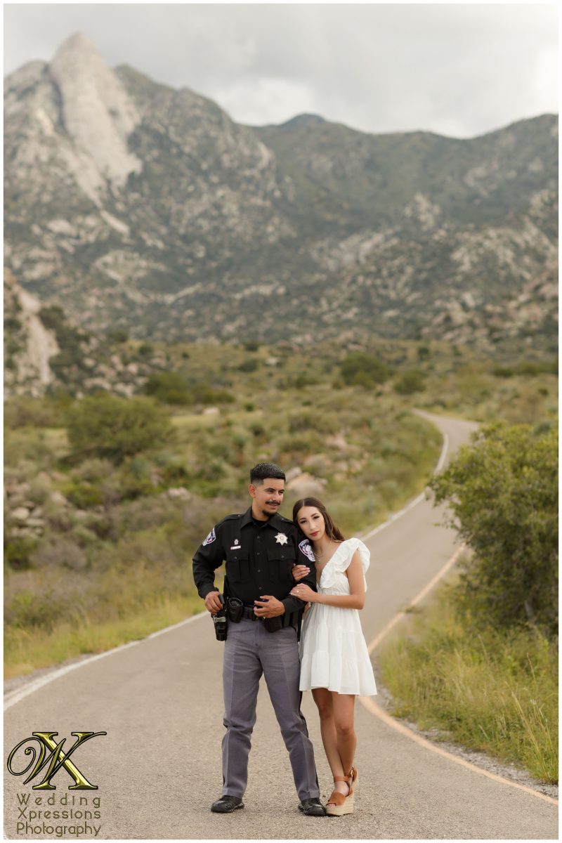 Couple laughing in uniform with the Organ Mountains backdrop.