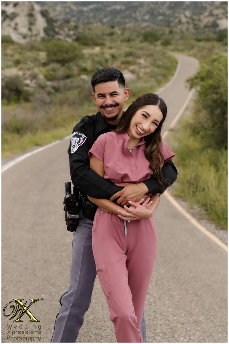 Alan in uniform hugging Illiana from behind in the desert.