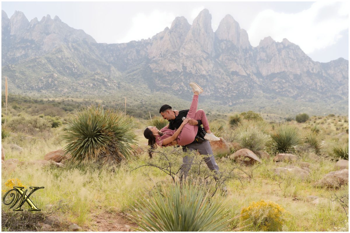 Romantic kiss at Aguirre Springs with mountain peaks behind.