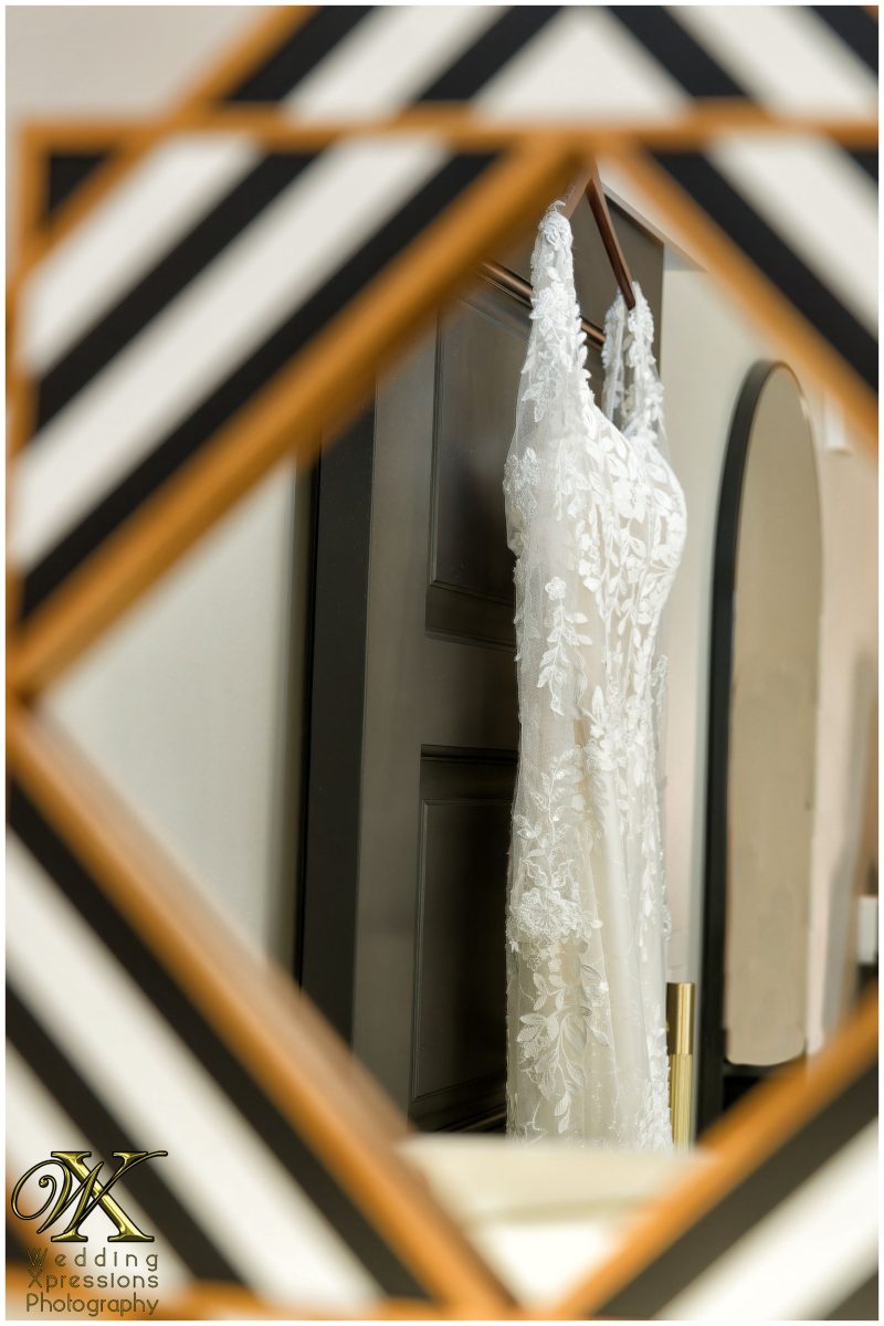 Elegant wedding dress hanging in a window at The Plaza Hotel Pioneer Park, El Paso.