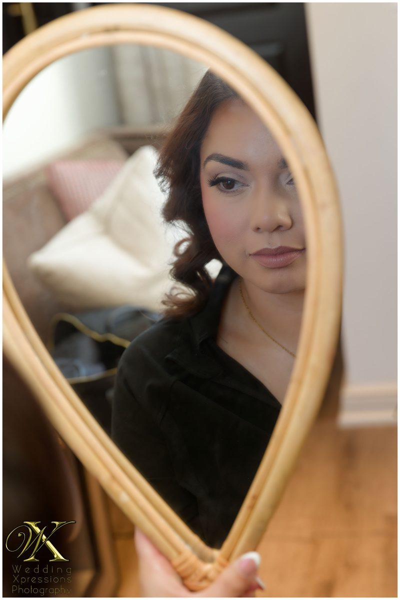 The bride's reflection in a mirror during prep at The Plaza Hotel Pioneer Park.