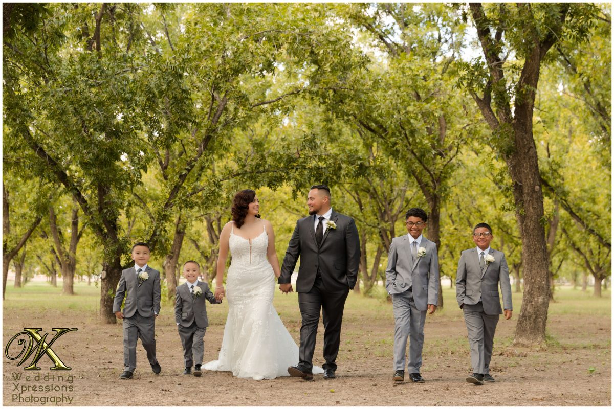 The family walking together through the sun-drenched pecan orchards of El Paso.