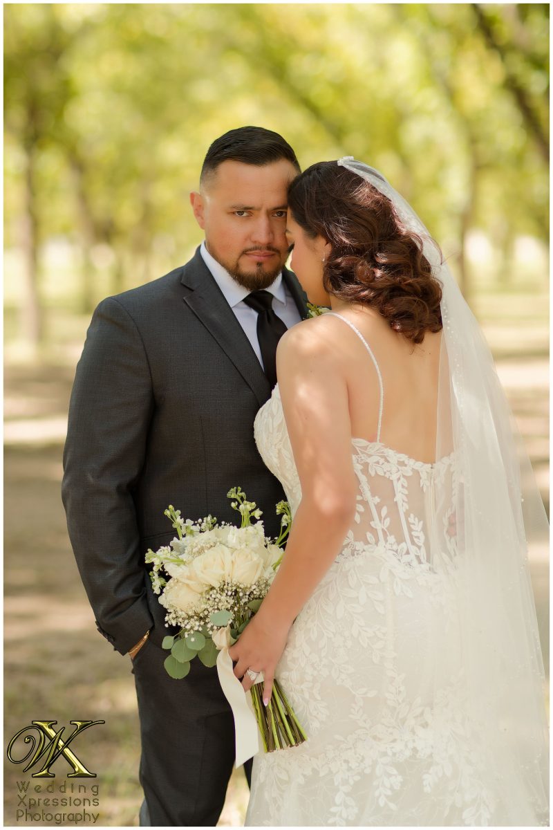 Intimate embrace between Christian and Melissa during their orchard portrait session.