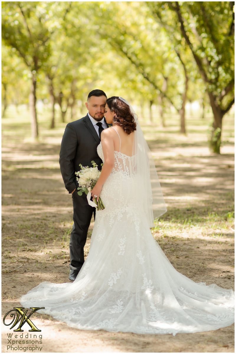 The groom whispering to his bride, an authentic and emotional orchard moment.