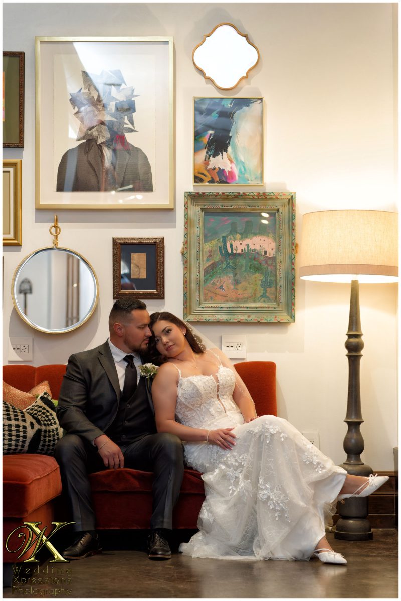 Cinematic portrait of Christian and Melissa seated in the lobby of The Plaza Hotel Pioneer Park.