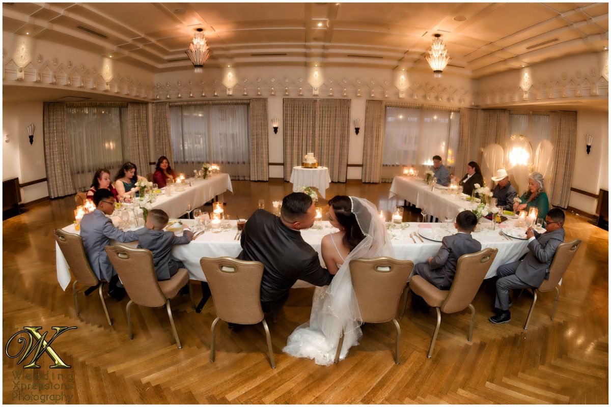 The couple sharing a laugh with their guests at the reception table.