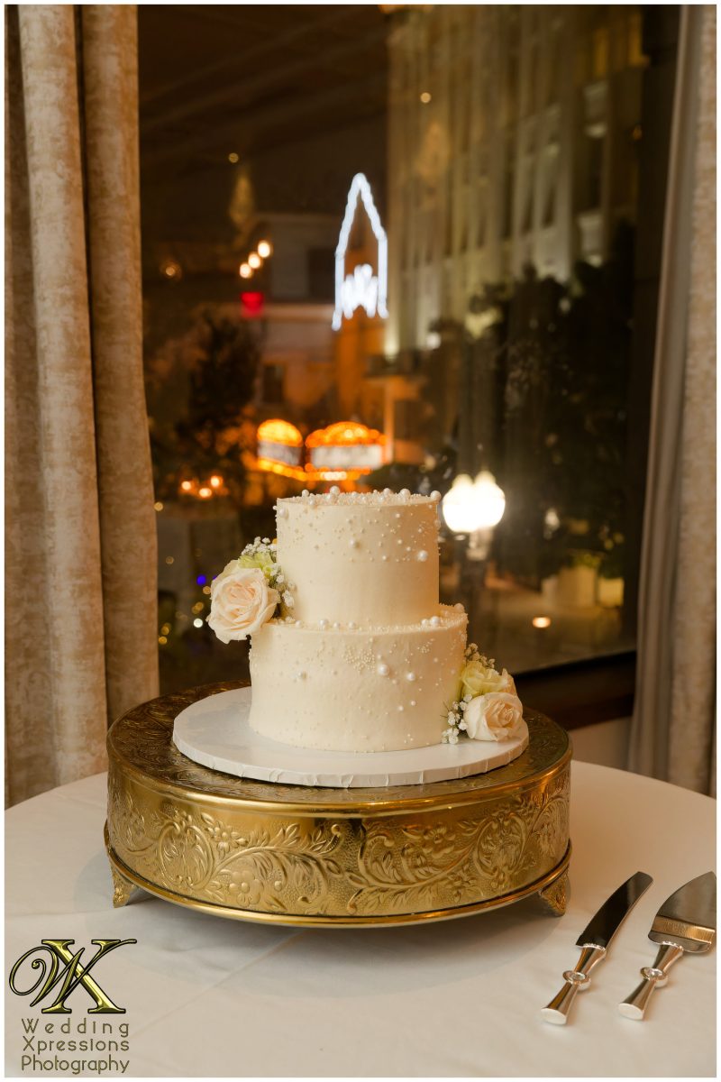 The elegant wedding cake being displayed during the reception festivities.