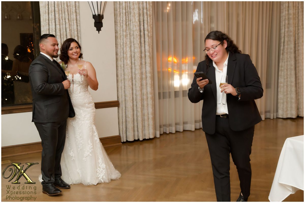Christian and Melissa laughing together as they listen to a toast to them.